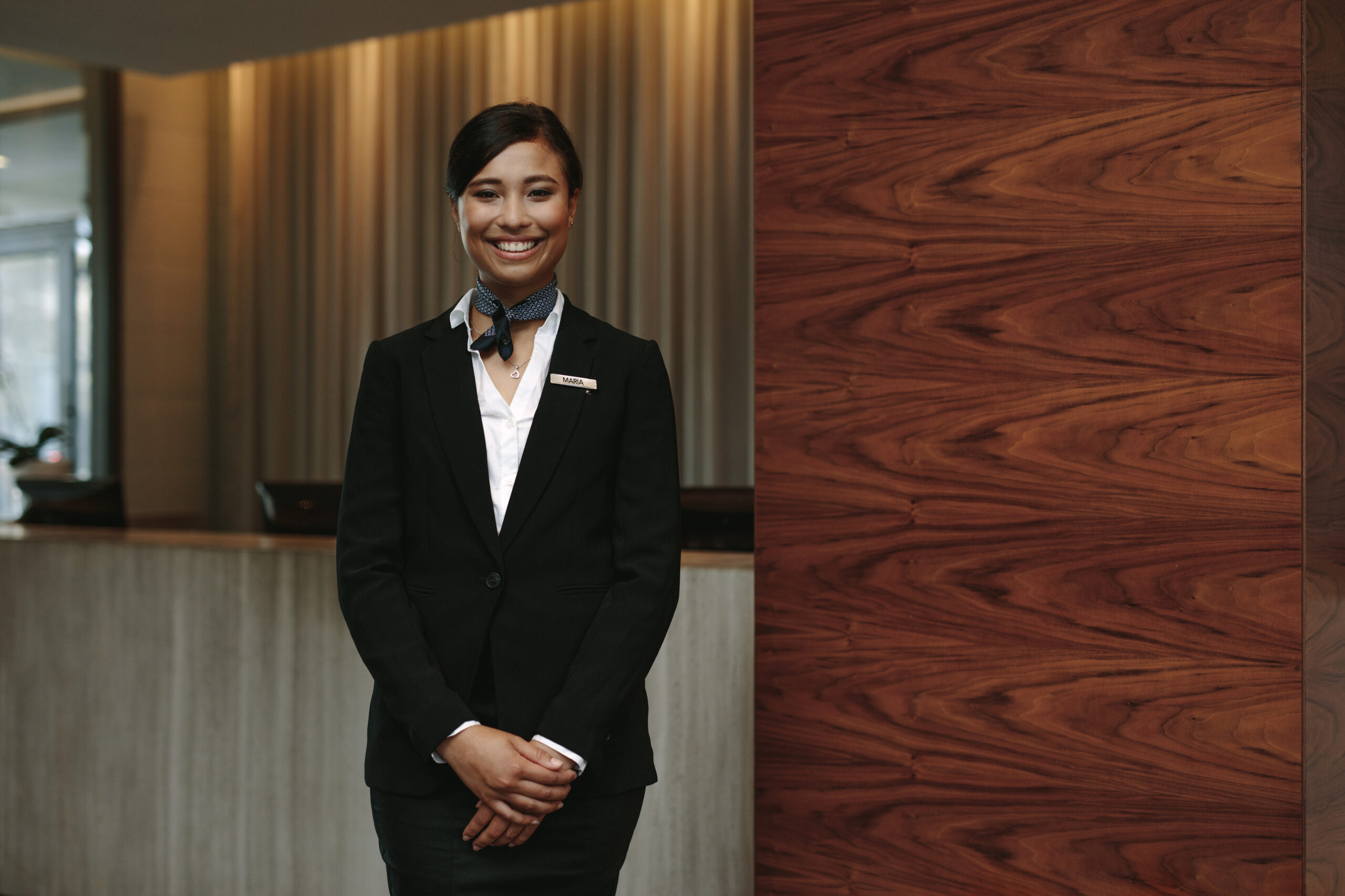Happy receptionist ready to welcome guests at hotel